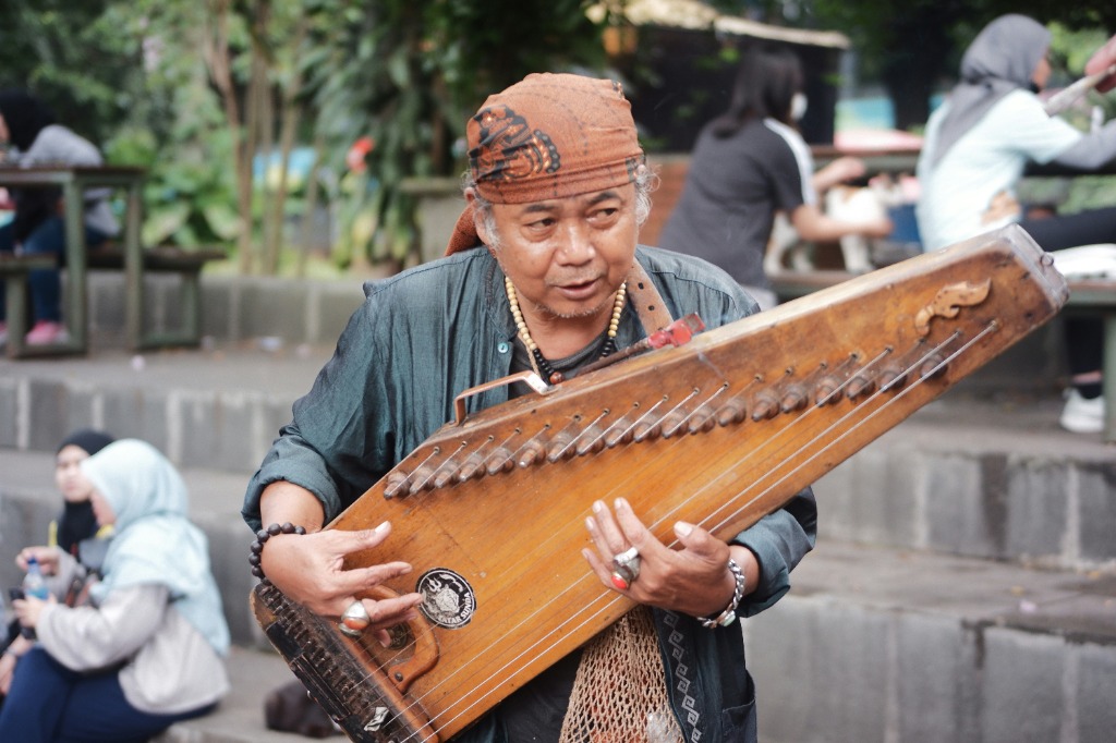 Musisi jalanan memainkan siter tradisional